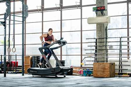 Laura Horváth, athlète professionnelle de fitness, s'entraine sur un tapis de course dans une salle de sport. 