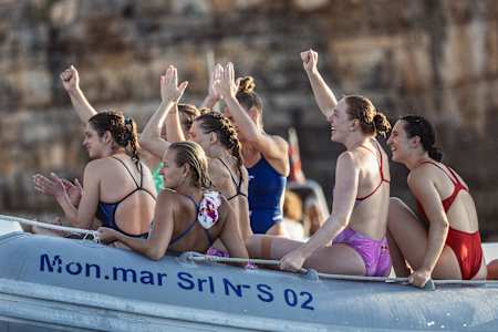 Red Bull athletes Rhiannan Iffland, Ginni van Katwijk, Ellie Smart, Molly Carlson, and Simone Leathead celebrate during the Red Bull Cliff Diving World Series event in Polignano a Mare, Italy