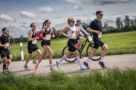 Leni Schömburg-Heuck corre ao lado de um ciclista na Wings for Life World Run da Red Bull em Munique, Alemanha.