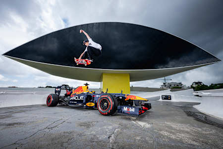 Guilherme Khury performs a high-flying skateboard trick above the Red Bull Racing Formula One car at Oscar Niemeyer Museum during the 2025 Red Bull Show Run in Curitiba, Brazil.