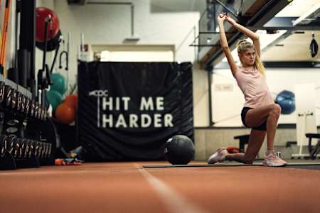 Konstanze Klosterhalfen estira en el dinámico Centro de Rendimiento de Atletas Red Bull de Thalgau, Austria, durante su intensa sesión de entrenamiento en noviembre de 2023.