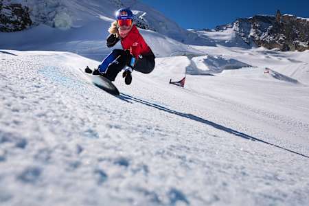 On October 11, 2025, Red Bull athlete Eva Adamczyková shreds the snowy slopes at Saas-Fee, Switzerland, displaying her dynamic snowboarding skills against a stunning alpine backdrop.
