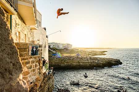 Yolotl Martinez of Mexico dives from the balcony during the first competition day of the third stop of the 2024 Red Bull Cliff Diving World Series in Polignano a Mare, Italy