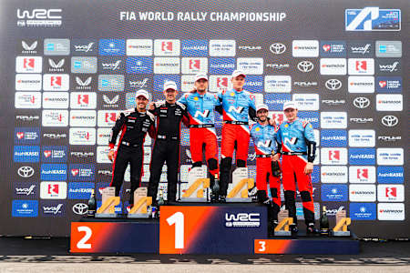 Ott Tänak and Martin Järveoja of Hyundai Shell Mobis World Rally Team celebrate first place at the 2025 FIA World Rally Championship podium in Lamia, Greece, alongside WRC's top teams