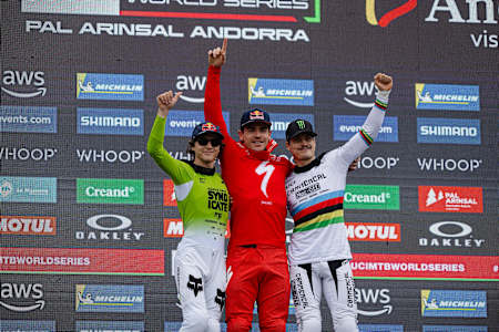 Loïc Bruni celebrates victory with Jackson Goldstone and Loris Vergier at the UCI Mountain Bike World Cup in Pal Arinsal, Andorra, July 2025.