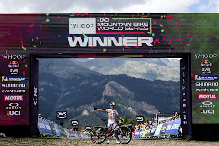 Tom Pidcock celebra la victoria en la línea de meta de la Copa del Mundo de Bicicleta de Montaña UCI en Pal Arinsal, Andorra, el 12 de julio de 2025, mostrando la máxima adrenalina de las carreras