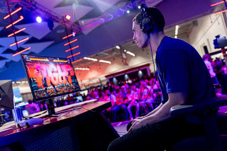 A competitive player enters the arena for Red Bull Golden Letters at Comic Con Cape Town 2025, set in the Cape Town International Convention Centre, energising the crowd with esports action.