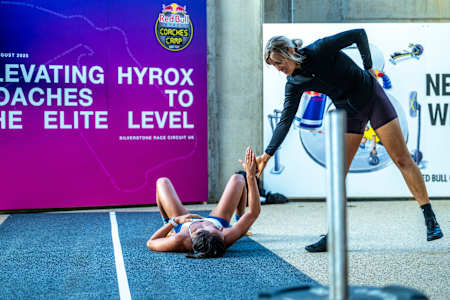 Teilnehmer:innen unterstützen sich gegenseitig während einer Trainingseinheit beim Red Bull HYROX Coaches Camp 2025 auf dem Silverstone Circuit, Großbritannien.