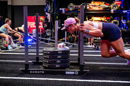 Athletes power through a strength challenge, pushing 100kg, at the Red Bull HYROX Coaches Camp in Silverstone Circuit, UK, with Red Bull Racing cars setting the scene in August, 2025.