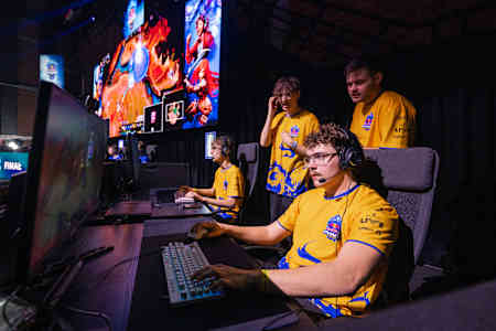 At Red Bull Phase Rush event in Warsaw, Poland, competitors intensely focus on gaming screens.