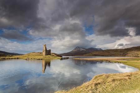 The ruined Ardvreck Castle reflected on the waters of Loch Assynt, Sutherland Shire, in the Scottish Highland