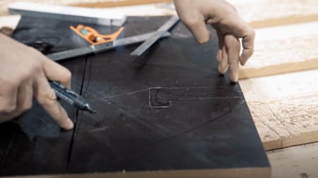 IOU Ramps Gründer Andreas Schützenberger zeichnet die richtigen Maße für die Füße der Skate-Rampe auf eine Siebdruckplatte.