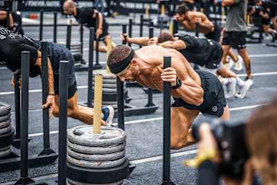 Un athlète pousse un sled lors des Championnats du monde Hyrox 2023.