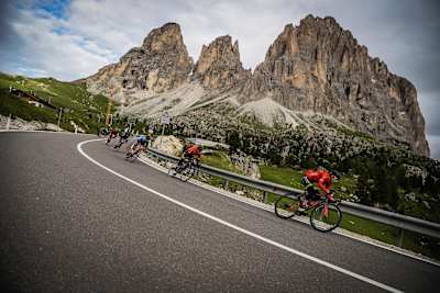 Riders come down a steep hill in the Dolomites.