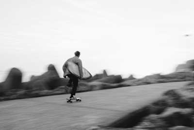 A skateboarder holding a suf board.