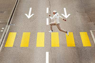 Decathlete Simon Ehammer performs a long jump over a pedestrian crossing.