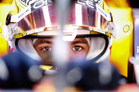 Max Verstappen at home in the cockpit of a Formula 1 car, ready to race.