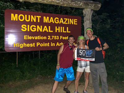 Colin O'Brady stands with friends next to Mount Magazine sign.