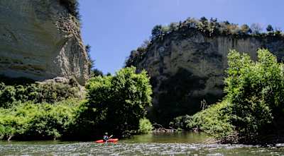 A man in a canoe paddles on the Rangitikei River in New Zealand.