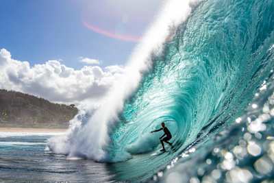 Surfer Kelly Slater rides the tube at Pipeline in Hawaii.