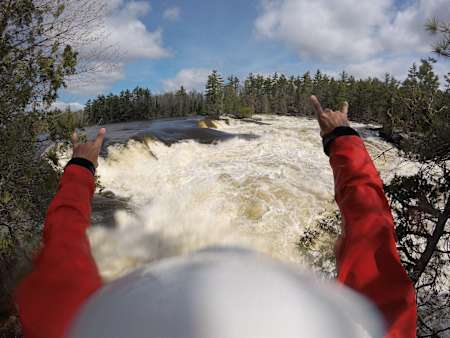 Benny Marr raises his arms in celebration at a rough river.