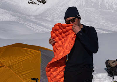 Xavier De Le Rue blows up an air mattress. For a good night's sleep and insulation from the cold ground a good mattress is vital.