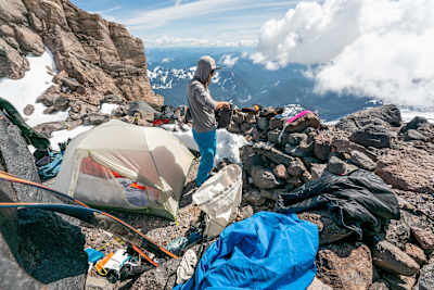 Cody Parker stands beside a tent on Mount Rainier.