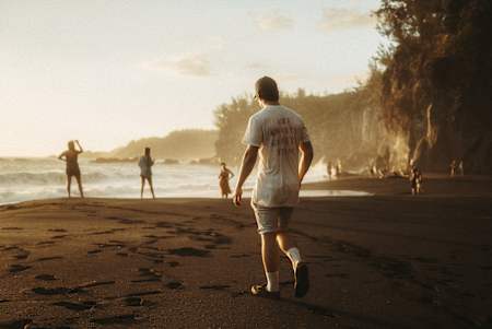 Le rider VTT Gaëtan Vigé marche sur une plage à La Réunion.
