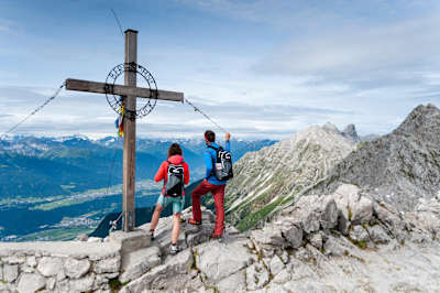 A couple take in views of the Austrian Alps near a hiking spot in Innsbruck, Austria.
