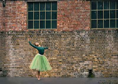 Chisato Katsura dances in front of a brick wall.