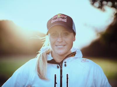 Camilla Pedersen lächelt mit einer Red Bull-Mütze und der Sonne im Rücken.