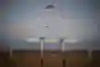 Two planes and paragliders seen in remote setting.