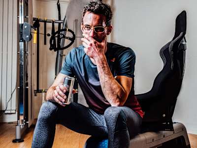 Thierry Neuville drinks a can of Red Bull in the gym.