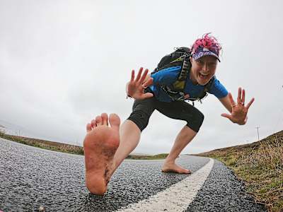 Anna McNuff poses for a roadside photograph during her Ultrarunning barefoot attempt in 2019.