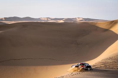 A photo of Cyril Despres' X-Raid Mini driving through sand dunes during stage 2 of Rally Dakar 2019.