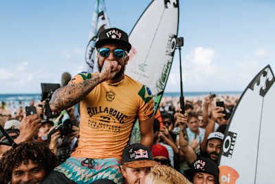 Italo Ferreira is chaired up the beach in Hawaii after winning the world surfing title.