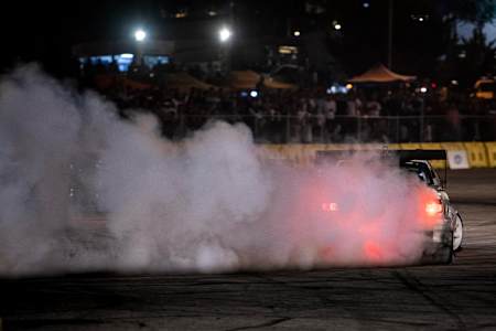 A photo of a drifting competitor burning rubber during Red Bull Car Park Drift in Amman, Jordan on August 16, 2019.