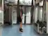 An athlete does tricep pull-ups on the pulley in the gym.