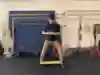An image of a man in a gym doing stretching exercises. 