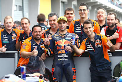 Aki Ajo (far left) celebrates a Moto2 podium for Miguel Oliveira.