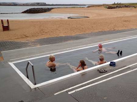 Warm up with friends – Nauthólsvík beach and hot tub in Iceland. 