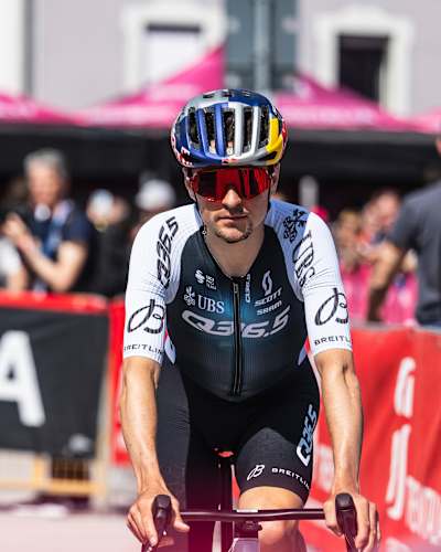 Thomas Pidcock powers through Fiume Veneto, Italy during the 2025 Giro di Italia, wearing his Red Bull helmet and representing elite cycling performance on the global stage