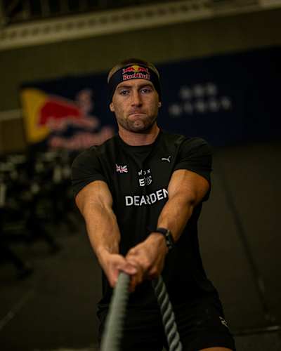 Jake Dearden at a HYROX competition, doing a rope pull