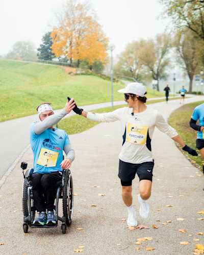 Florian Neuschwander teilt ein High Five mit einem Rollstuhlfahrer beim Red Bull 1 Pro vs. 80 Amateure in München, Deutschland, am 31. Oktober 2025, um Energie und Inklusion zu feiern