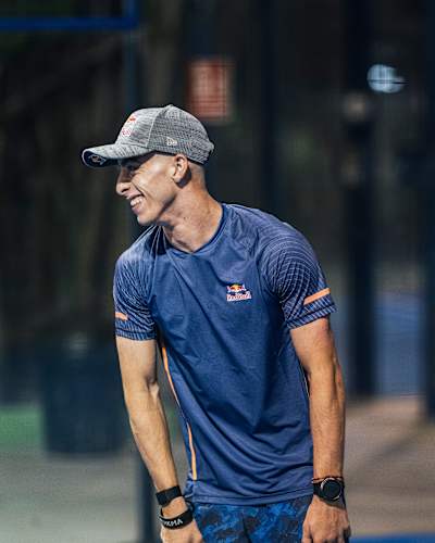 Red Bull-Athlet und MotoGP-Fahrer Pedro Acosta lächelt, während er einen Padel-Schläger hält 