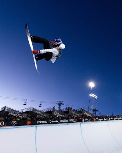 Scotty James launches above the halfpipe during the Laax Open in Laax, Switzerland, on 18 January 2025, beneath the floodlights and cheering crowd