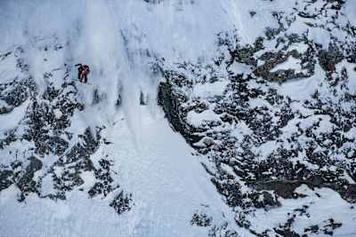 An image of a snowboarder jumping off a cliff on the Bec Des Rosses, Verbier.