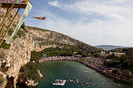 Ucraineanul Sacha Kutsenko face o scufundare în stâncă în timpul Red Bull Cliff Diving în Grecia. 