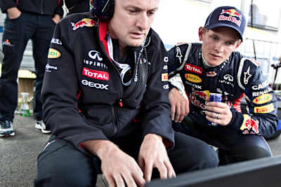 A photo of Thomas Morgenstern checking the telemetry of an F1 Red Bull Racing car in 2012.