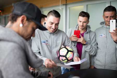 Neymar Jr signs balls and soccer equipment for the 2017 Neymar Jr Five winners Team Romania at Paris St Germain's training ground in Paris.